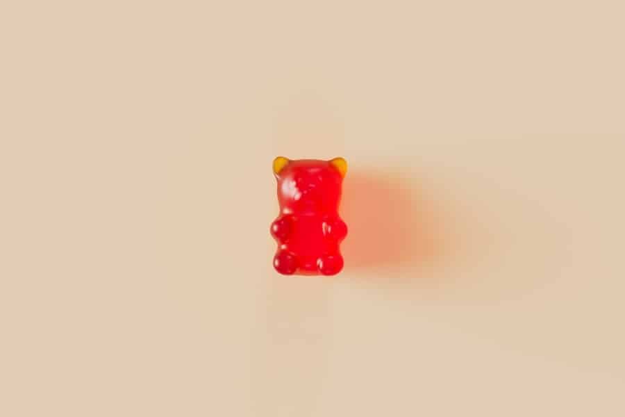 Single red gummy on a soft background, a reminder to start small with Delta-8