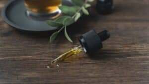 Hemp oil bottle beside green leaves, a product pairing CBD and Delta-8