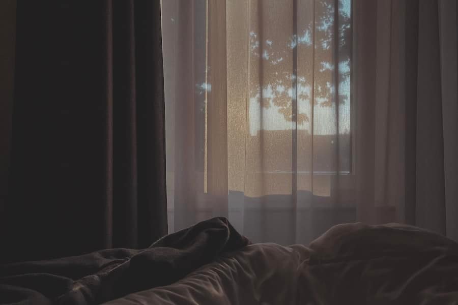 Early daylight filtering through a sheer bedroom curtain