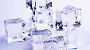 Clear ice cubes stacked on a pale surface