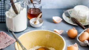 Baking ingredients and a mixing bowl laid out on a work surface