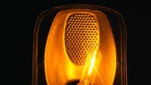 A glowing filament bulb lit against a dark background