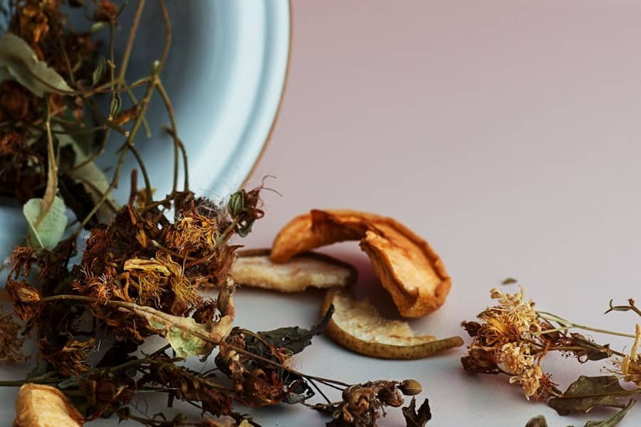 Dried flowers and botanicals spilling from a pale bowl