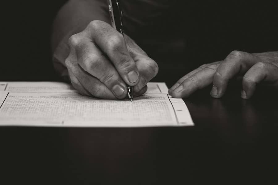 A hand filling in a printed form with a pen